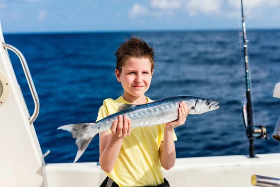 Child holding a small barracuda